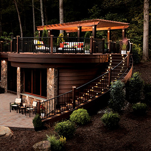 Trex Signature® railing in Charcoal Black complements the vastness of a Transcend deck in Lava Rock and Tiki torch as shown in the Shenandoah Collection